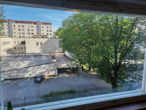 a view of a parking lot from a window at Tunnelmaa Turun sydämessä - Ambient 37m2 at the heart of Turku in Turku