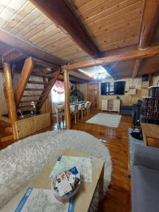 a large living room with wooden ceilings and a table at Cabana Stînă - Duplex Montan in Topliţa