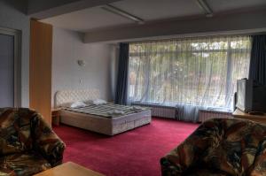 a bedroom with a bed and a large window at Neon Guest Rooms in Shumen