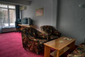 a living room with a chair and a television at Neon Guest Rooms in Shumen