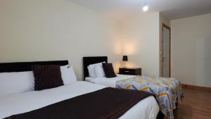 Un dormitorio con dos camas y una mesa con lámpara. en Royal Living Apartment, en Mánchester