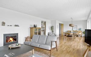 un salon avec un canapé et une cheminée dans l'établissement 4 Bedroom Beach Front Home In Thyholm, à Thyholm