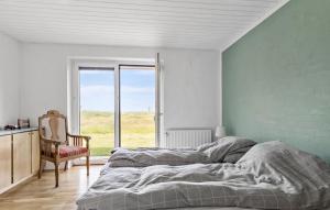 une chambre avec un lit, une chaise et une fenêtre dans l'établissement 4 Bedroom Beach Front Home In Thyholm, à Thyholm