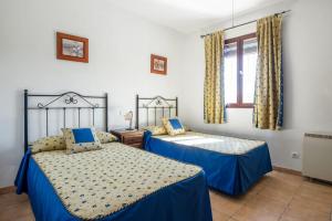 ein Schlafzimmer mit zwei Betten und einem Fenster in der Unterkunft Casa Rural El Rincón in Carcabuey + 18 Fotos
