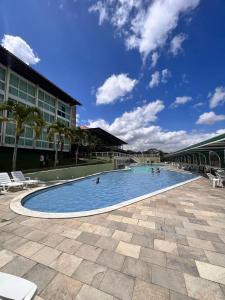 a swimming pool with people in the water at Flat Fabuloso 808 Villa Hípica in Gravatá