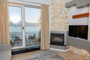 sala de estar con chimenea y vistas al agua en Premium Beach Apartments Jonufer, en Vlorë