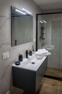 a bathroom with a white sink and a mirror at AMarescaladeiturchy Scaladeiturch in Realmonte