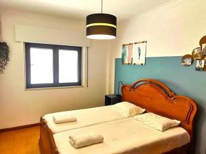 a bedroom with two beds and a window at Mountain View Beach House in Costa da Caparica