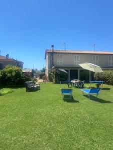 un patio con dos sillas azules y una sombrilla en Casa Ariel, en Lucca