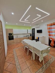 a dining room with a table and a kitchen at Casa Vera in Piana degli Albanesi