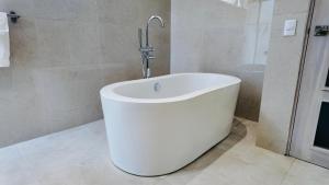 a white bath tub in a bathroom with a shower at Villas Agua Dulce Sosua in Sosúa