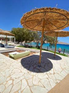 a large umbrella sitting on a patio near the water at Villa Aristoteles in Halki