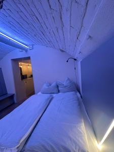 a white bed in a room with a ceiling at Soulfactory Apartments in Neu Ulm