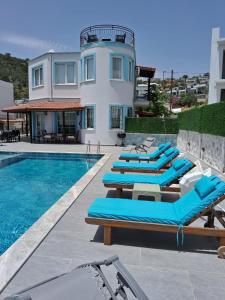 a villa with a swimming pool with blue lounge chairs at Villa Manolya in Kalkan