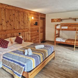 a bedroom with a bed and two bunk beds at Le Nid de l'Aigle in Champoluc