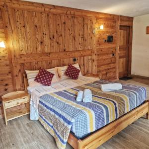 a bedroom with a bed in a room with wooden walls at Le Nid de l'Aigle in Champoluc