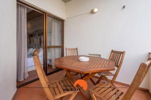 a wooden table and chairs in a room with a bed at #212 Vila Magna 106B by Home Holidays in Vale de Pedras