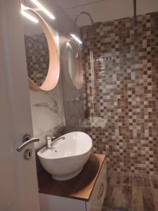 奥托佩尼Blue Condo Otopeni的浴室里有白色洗手池和镜子