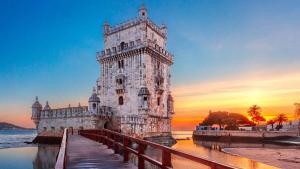 a large white building with a bridge in the water at GuestReady - Sunshine Belém in Lisbon +30 photos