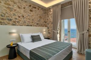 a bedroom with a bed and a view of the ocean at YeeOn Boutique Hotel, Gythio - Historic Hotels of Europe in Gythio +100 photos