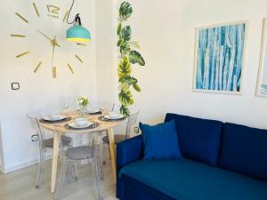 salon ze stołem i zegarem na ścianie w obiekcie Przytulny Apartament 100m od plaży w mieście Torrevieja