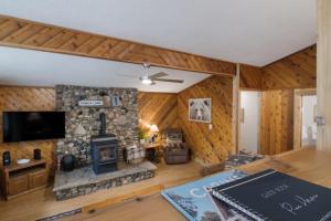 a living room with a stone fireplace and a tv at 12pm CHECK OUT WINTER Schuss Mountain in Rapid City +22 photos