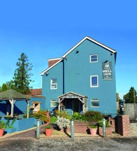 a blue building with plants in front of it at The Well Inn in Shepton Mallet