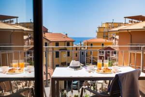 a table with food on a balcony with a view of a city at Kriss Apartments in Deiva Marina