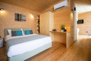 コインブラにあるCasas do Pátioの白いベッドと木製の壁が備わるベッドルーム1室が備わります。