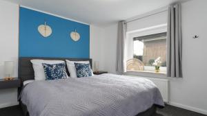 Schlafzimmer mit einem Bett mit blauem Akzent in der Unterkunft Nahe Kiel, 4 Betten, 2 Schlafzimmer Parkplatz, Terrasse, 3km zum Strand in Osdorf + 28 Fotos