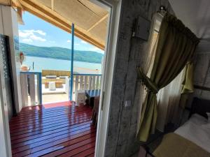 a room with a balcony with a view of the water at CABANA ȘTIMA - CAZANELE DUNĂRII -Șvinița in Sviniţa