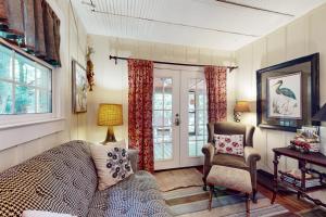 a room with a bed and a chair and a window at Pine Retreat Cottage in Black Mountain