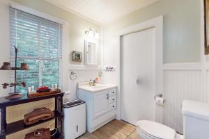 a white bathroom with a toilet and a sink at Pine Retreat Cottage in Black Mountain +18 photos