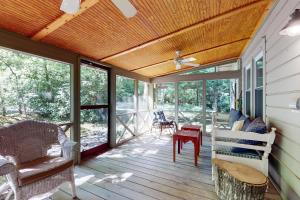 a screened porch with a wooden ceiling and windows at Pine Retreat Cottage in Black Mountain