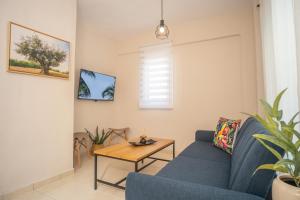 a living room with a blue couch and a table at Cozy Home in Kriopigi