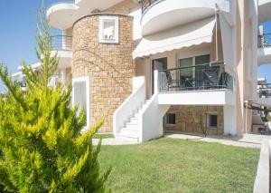 a villa with a balcony and a yard at Cozy Home in Kriopigi