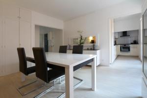 a white dining room table and black chairs in a room at Riverside Toulouse (Harmony) in Toulouse