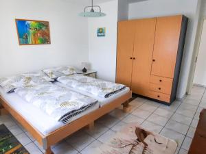 a bedroom with a bed and a wooden cabinet at Apartment Lakeview La Marea by Interhome in Piazzogna
