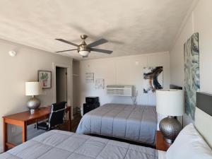 a bedroom with a bed and a desk and a ceiling fan at Lake Hudson Inn in Spavinaw