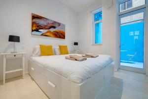 a white bedroom with a large white bed in it at Trendy 1 Bedroom in the Heart of Valletta in Valletta +32 photos
