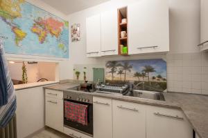 una cocina con armarios blancos y un mapa en la pared en Bergschlössl Oberaudorf, en Oberaudorf