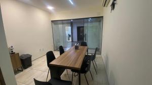 comedor con mesa de madera y sillas negras en Apart Hotel Garvey - Ciany Monteiro, en Brasilia 22 fotos más