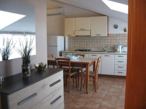 a kitchen with a table and chairs and a dining room at Nino's Apartments in Giardini Naxos