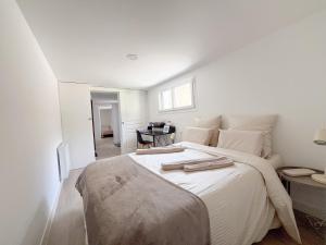 a white bedroom with a large bed with white sheets at Superbe Maison Loft 80 m2 au calme avec jardin et parking privés proche Paris Disney la vallée village in Fontenay-sous-Bois