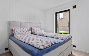 a large bed in a room with a window at 4 Bedroom Stunning Home In Risør in Risør