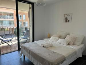 a bedroom with a bed and a balcony with a chair at Appartement Bormes in Bormes-les-Mimosas +36 photos