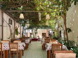 a dining room with tables and chairs and trees at Kekik Butik Otel in Çeşme