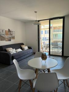 a living room with a couch and a table and chairs at Appartement Bormes in Bormes-les-Mimosas