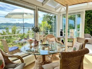 a dining room with a glass table and chairs at Holiday Home Seepanorama by Interhome in Wangen