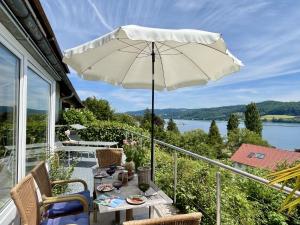 a patio with a table and an umbrella on a balcony at Holiday Home Seepanorama by Interhome in Wangen +52 photos